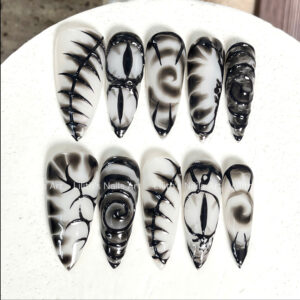 Handpainted goth press on nails featuring black 3d demon eyes and smoke ink marble art on edgy stiletto shapes