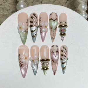 Luxury Y2K press on nails with 3D white flowers, metallic gold line art, and pastel green pink hearts on stiletto shape
